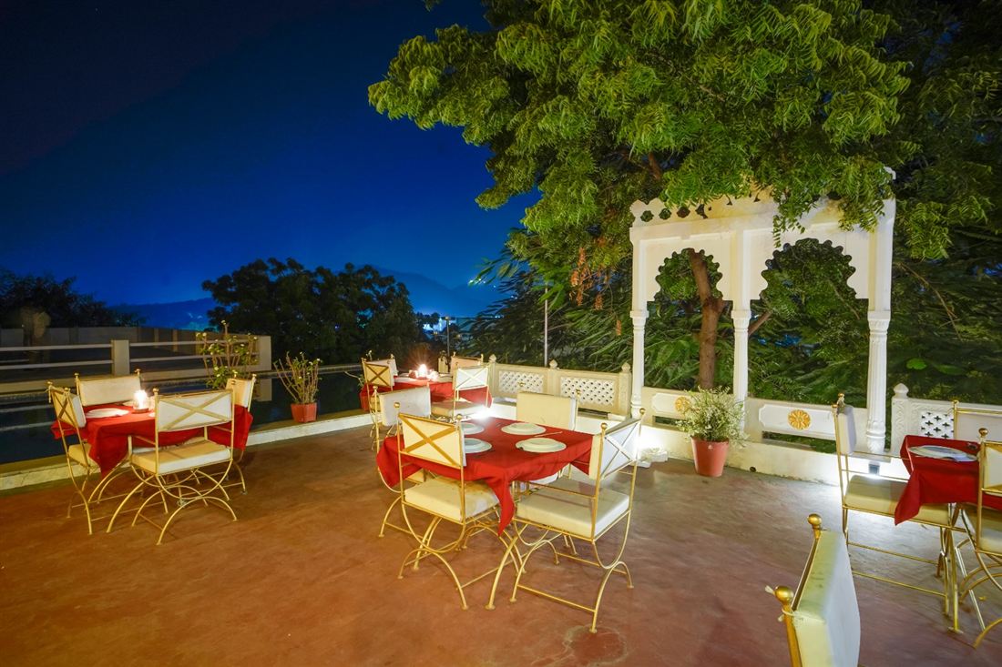 Arched rooftop dining nook lit at dusk