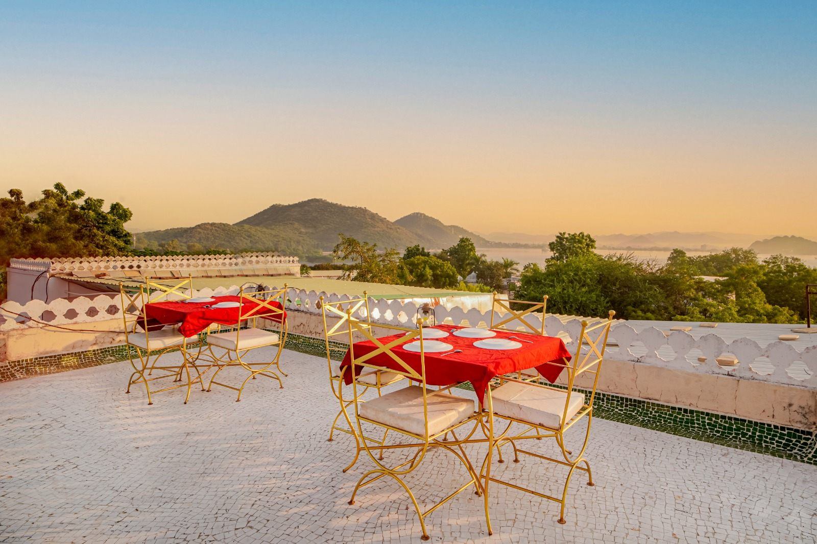 Rooftop terrace at Vikram Garh Lakeview overlooking Fateh Sagar and the Aravalli hills at sunset, Udaipur